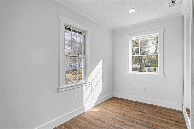 unfurnished room featuring baseboards, ornamental molding, wood finished floors, and a healthy amount of sunlight