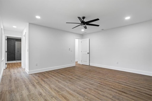 spare room featuring recessed lighting, wood finished floors, a ceiling fan, and baseboards