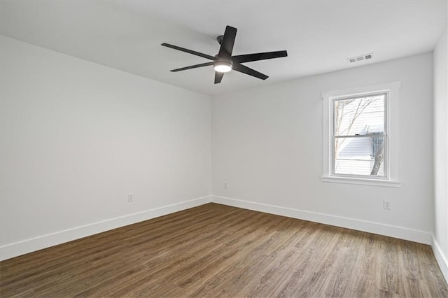 unfurnished room featuring baseboards, visible vents, ceiling fan, and dark wood-style flooring