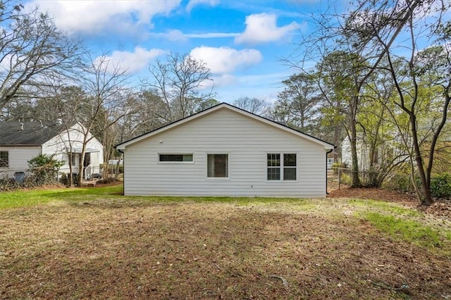 back of house featuring a yard and fence