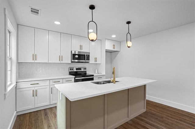 kitchen featuring light countertops, appliances with stainless steel finishes, a kitchen island with sink, white cabinets, and a sink