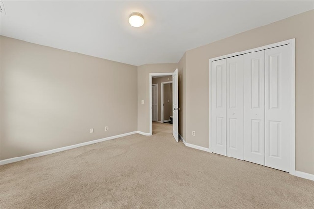 unfurnished bedroom with light carpet and a closet