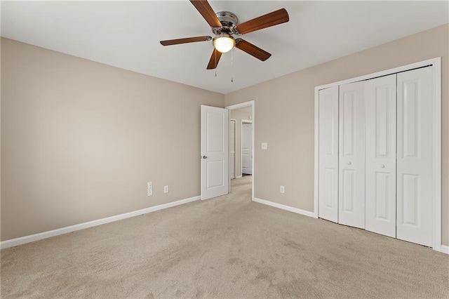 unfurnished bedroom with ceiling fan, a closet, and light carpet