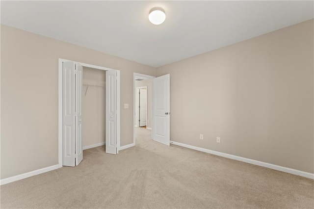 unfurnished bedroom with light colored carpet and a closet