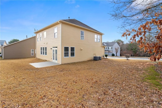 back of house with central AC, a yard, and a patio