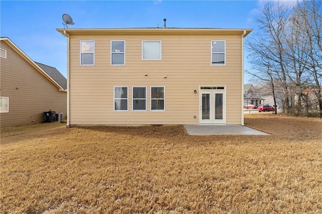 rear view of house featuring cooling unit, a lawn, and a patio