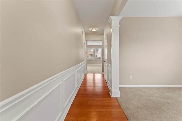 hall with carpet floors and ornate columns