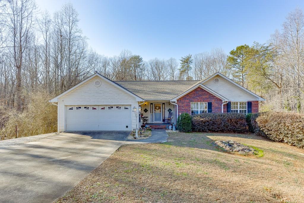 ranch-style house with a garage and a front lawn