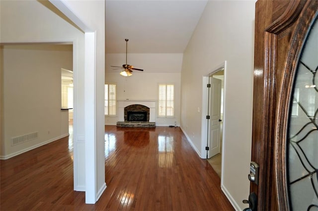 interior space featuring visible vents, baseboards, high vaulted ceiling, and dark wood finished floors