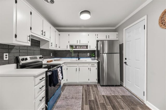 kitchen with dark wood-type flooring, white cabinets, sink, appliances with stainless steel finishes, and tasteful backsplash