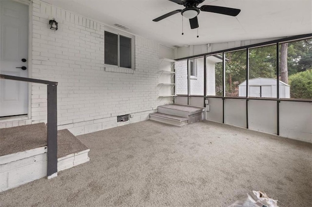 interior space with carpet flooring, ceiling fan, lofted ceiling, and brick wall