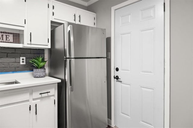 kitchen featuring backsplash, white cabinetry, and stainless steel refrigerator