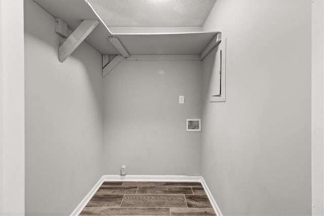 clothes washing area with dark hardwood / wood-style flooring, washer hookup, and a textured ceiling