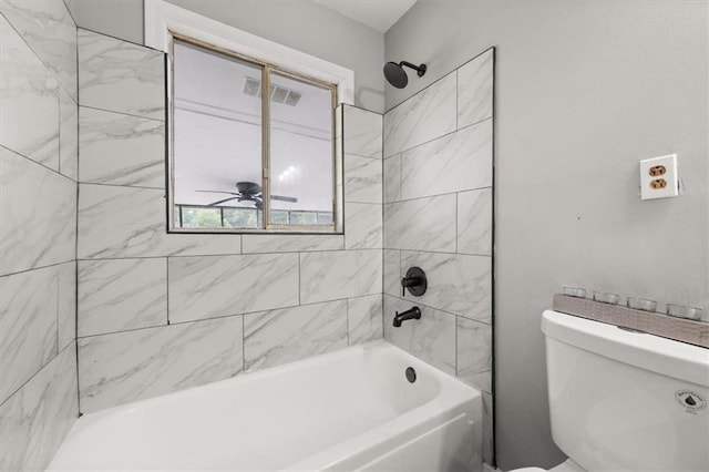 bathroom with ceiling fan, toilet, and tiled shower / bath