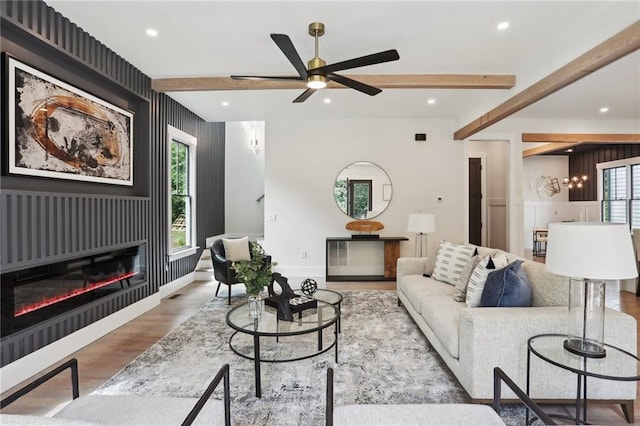 living room with beamed ceiling, ceiling fan, and light hardwood / wood-style floors