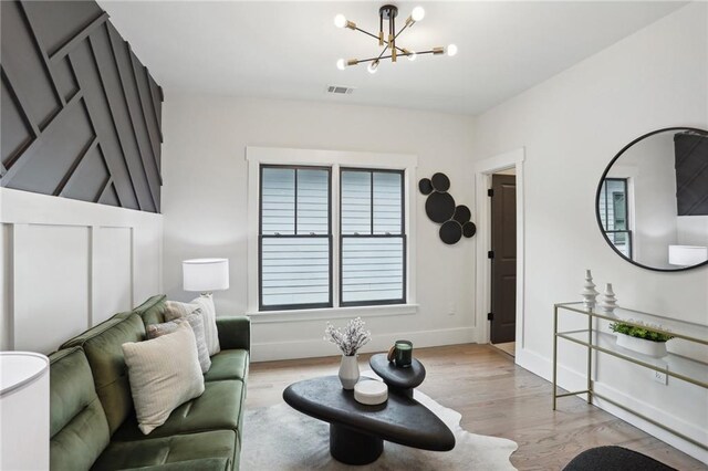 living room featuring a chandelier and light hardwood / wood-style floors