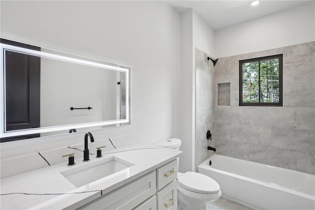 full bathroom featuring vanity, tiled shower / bath combo, and toilet