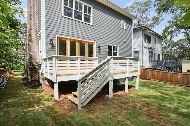 rear view of house featuring a yard and a wooden deck