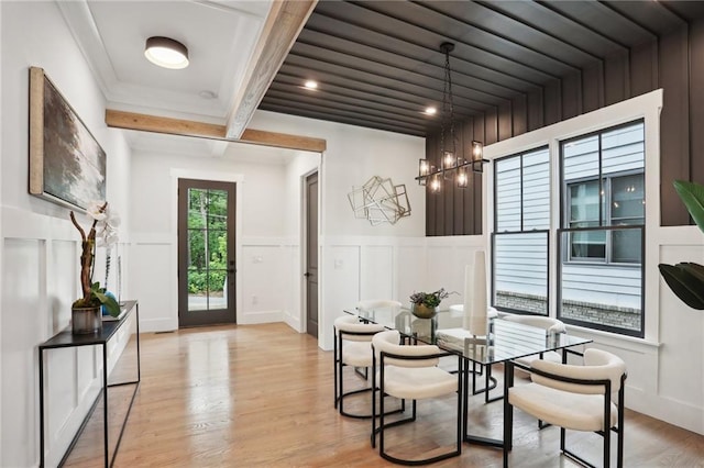 dining room featuring beam ceiling and light wood-type flooring