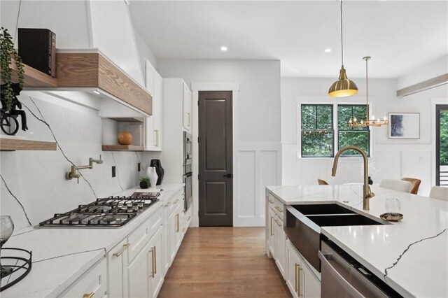 kitchen with white cabinets, light stone countertops, and sink