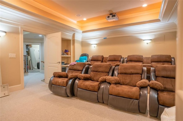 carpeted home theater room featuring a tray ceiling and crown molding