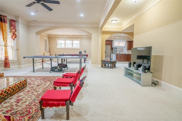 rec room with ceiling fan, crown molding, and light carpet