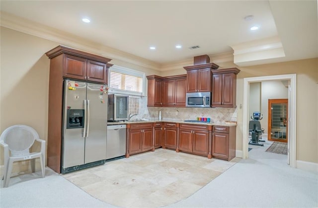 kitchen featuring light carpet, stainless steel appliances, tasteful backsplash, and ornamental molding