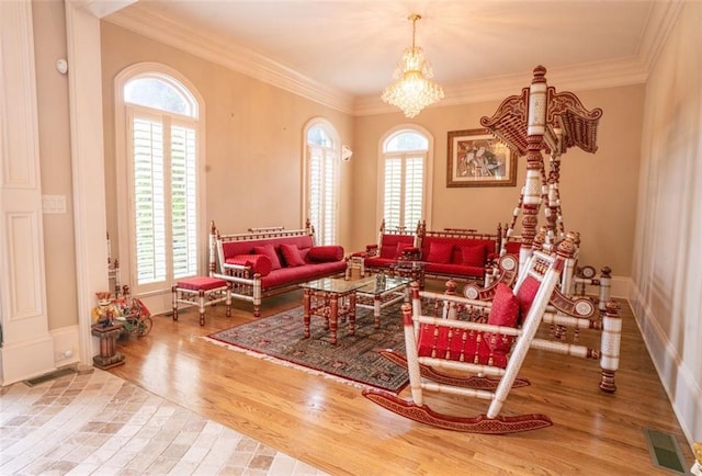 sitting room featuring wood-type flooring, ornamental molding, and a healthy amount of sunlight