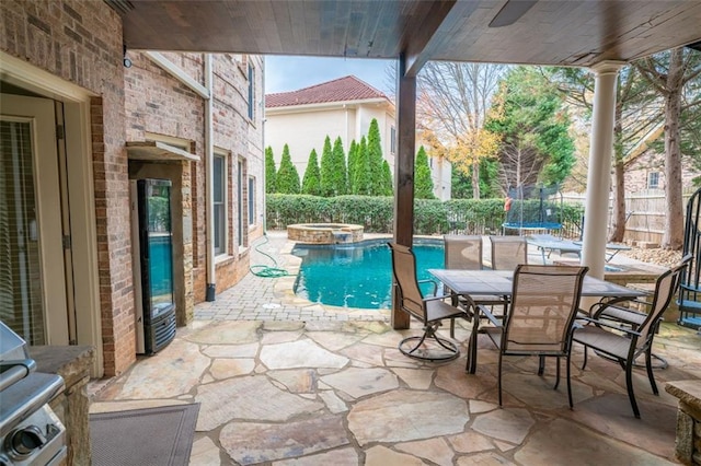 view of swimming pool with an in ground hot tub, a patio, and a trampoline