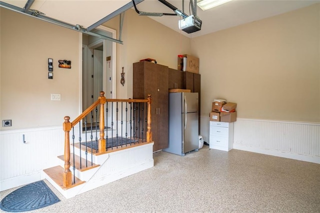 garage featuring a garage door opener and stainless steel refrigerator