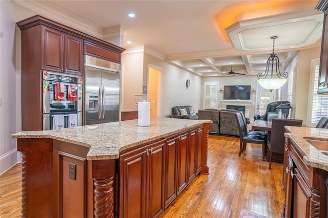 kitchen with ceiling fan, stainless steel appliances, coffered ceiling, light hardwood / wood-style floors, and a kitchen island