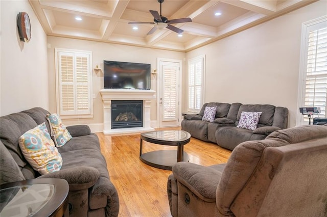 living room featuring beamed ceiling, hardwood / wood-style flooring, ceiling fan, and coffered ceiling