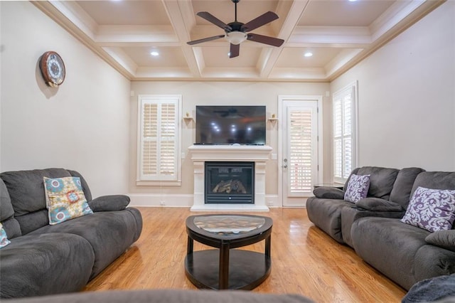 living room with beam ceiling, light wood-type flooring, ceiling fan, and coffered ceiling