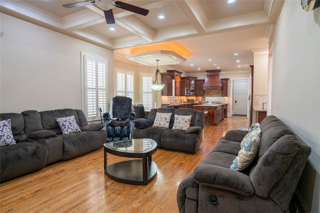 living room with coffered ceiling, ceiling fan, beam ceiling, and light hardwood / wood-style flooring