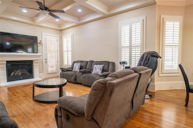 living room featuring a wealth of natural light, light hardwood / wood-style flooring, and coffered ceiling