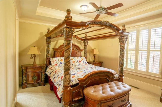 bedroom featuring a raised ceiling, ceiling fan, carpet flooring, and crown molding