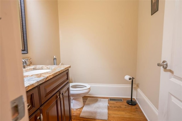 bathroom featuring hardwood / wood-style flooring, vanity, and toilet