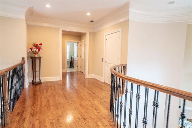 hallway with light hardwood / wood-style floors and ornamental molding