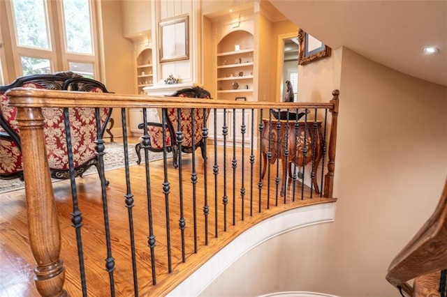 stairs featuring wood-type flooring and built in features