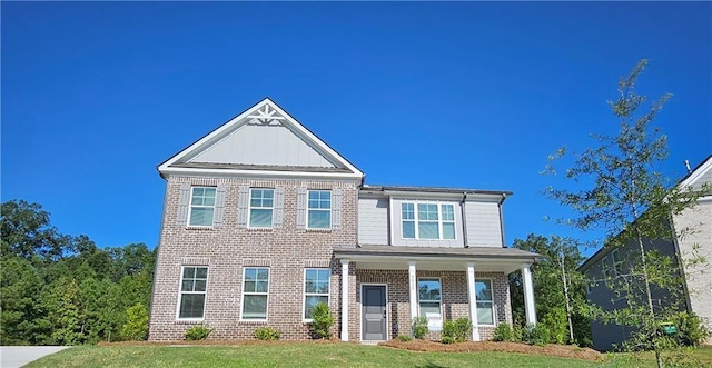 view of front facade with a front yard and covered porch