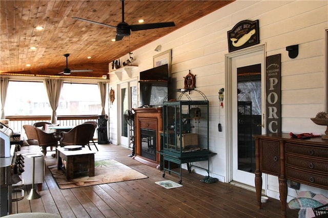 interior space featuring wood ceiling, a fireplace, vaulted ceiling, and a ceiling fan