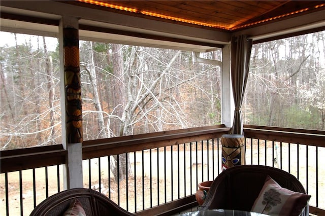 sunroom / solarium featuring plenty of natural light, wood ceiling, and vaulted ceiling