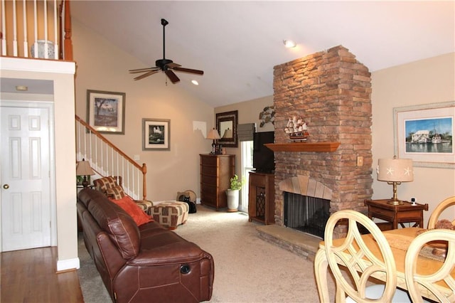 living room with ceiling fan, high vaulted ceiling, stairway, and a fireplace