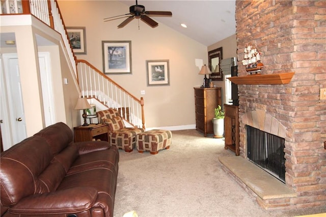 living area with a fireplace, stairway, a ceiling fan, carpet flooring, and vaulted ceiling