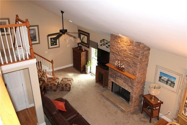 living room with a fireplace, a ceiling fan, vaulted ceiling, baseboards, and stairs