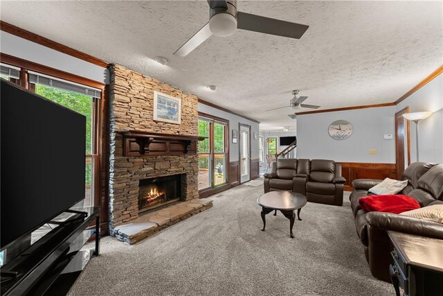 1172 Malvern Hunt Ct, Lawrenceville, GA 30043 - carpeted living area featuring a ceiling fan, ornamental molding, healthy amount of natural light, a stone fireplace, and wainscoting