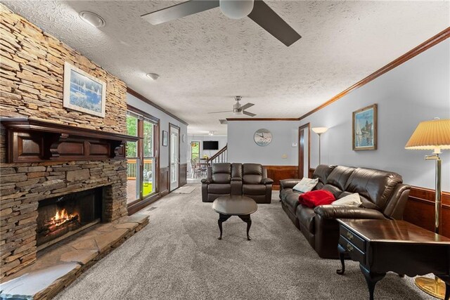 1172 Malvern Hunt Ct, Lawrenceville, GA 30043 - carpeted living area featuring a ceiling fan, wainscoting, a textured ceiling, crown molding, and stairs