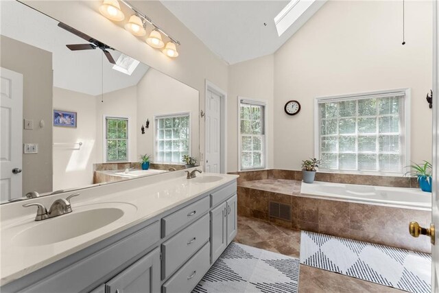 1172 Malvern Hunt Ct, Lawrenceville, GA 30043 - bathroom with a skylight, high vaulted ceiling, ceiling fan, double vanity, and a garden tub