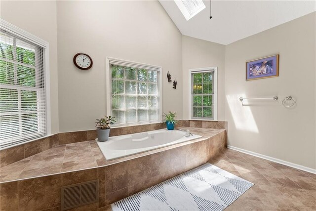 1172 Malvern Hunt Ct, Lawrenceville, GA 30043 - bathroom featuring plenty of natural light, a skylight, a bath, high vaulted ceiling, and tile patterned flooring