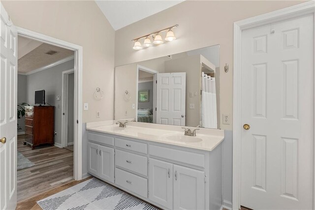 1172 Malvern Hunt Ct, Lawrenceville, GA 30043 - ensuite bathroom with double vanity, lofted ceiling, and wood finished floors